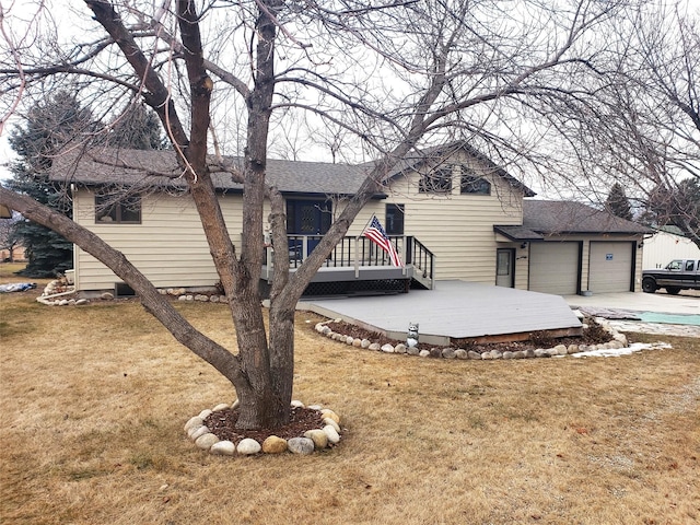 view of front of property featuring a garage, a front yard, concrete driveway, and a shingled roof