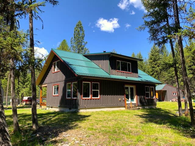 view of front of property featuring entry steps, metal roof, crawl space, board and batten siding, and a front yard