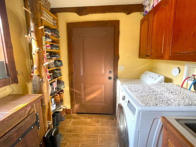 clothes washing area with cabinet space, washing machine and dryer, and wood finish floors