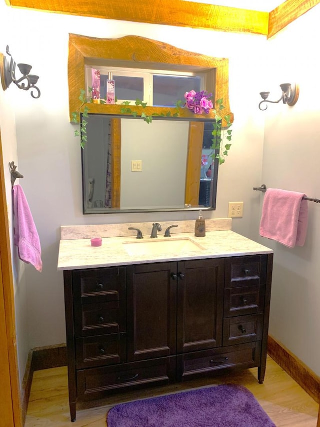 bathroom with vanity, baseboards, and wood finished floors