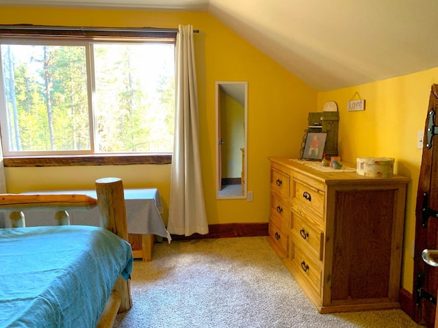 bedroom featuring baseboards, vaulted ceiling, and light colored carpet