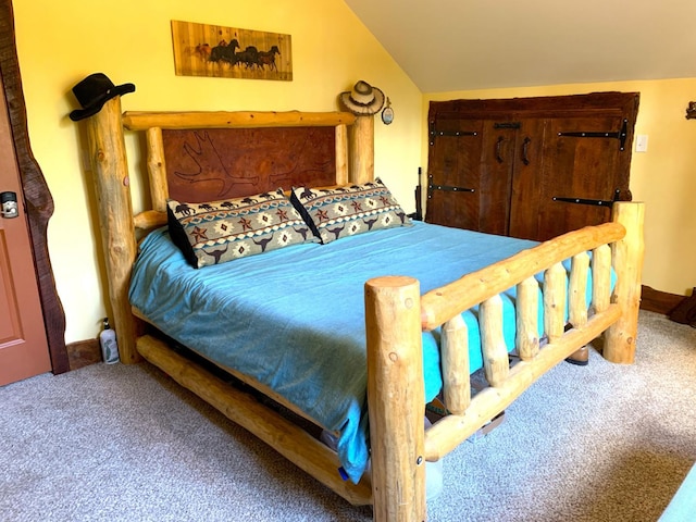 carpeted bedroom with lofted ceiling