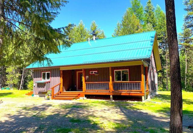 view of front of property featuring covered porch, metal roof, and board and batten siding