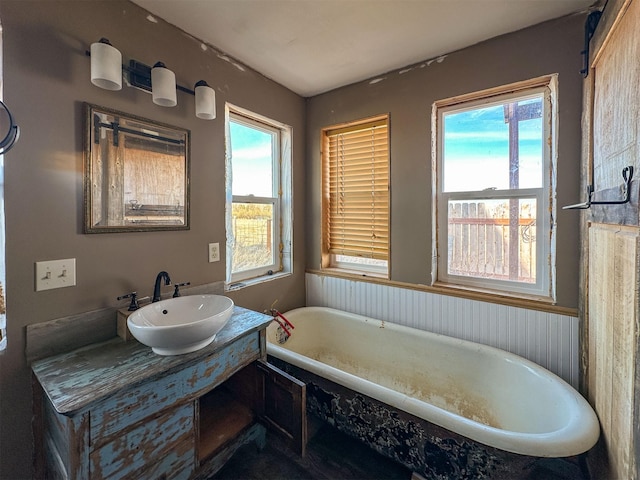 full bathroom featuring a soaking tub and vanity