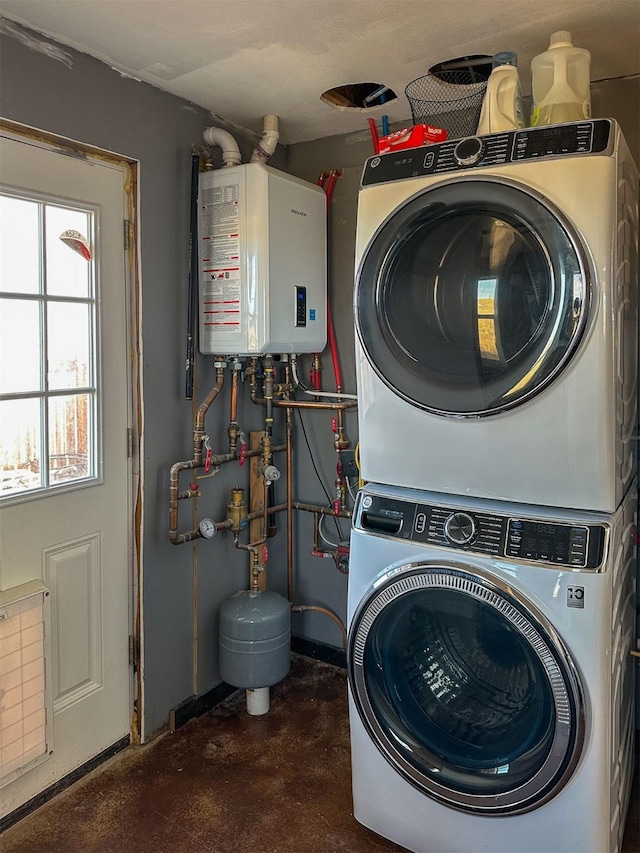 laundry area featuring stacked washer / drying machine, laundry area, and tankless water heater