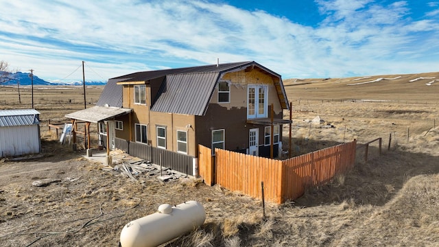 exterior space with fence, metal roof, and a gambrel roof