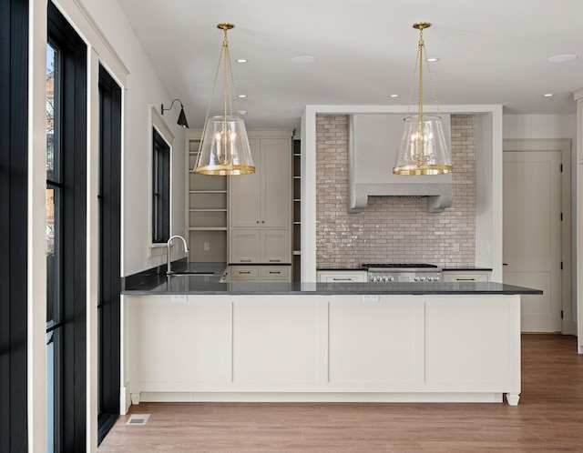 kitchen with range, dark countertops, a sink, and open shelves