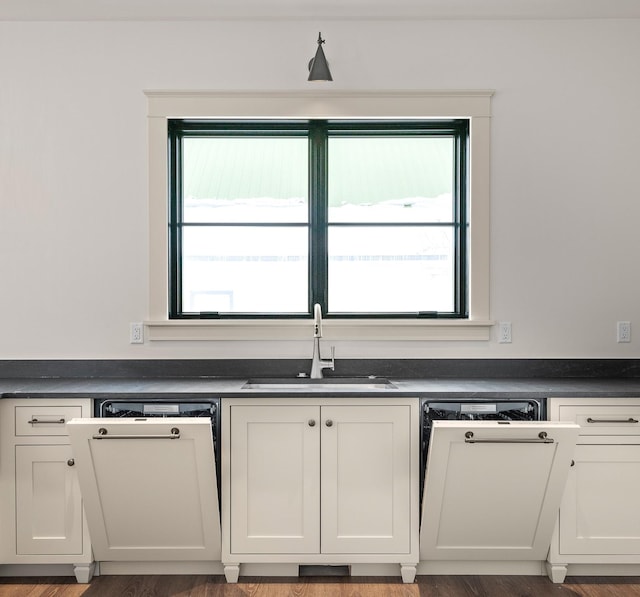 kitchen with plenty of natural light, dark countertops, and a sink