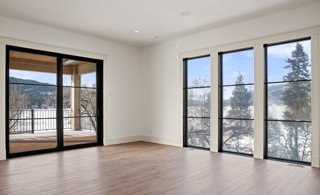 empty room with visible vents, baseboards, and wood finished floors