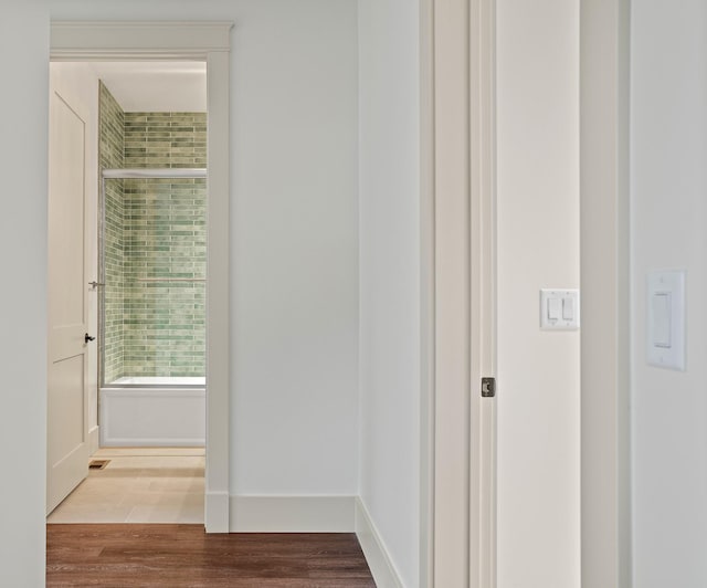 corridor featuring wood finished floors and baseboards