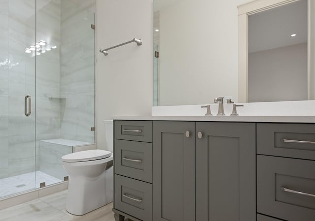 bathroom with toilet, a shower stall, and vanity