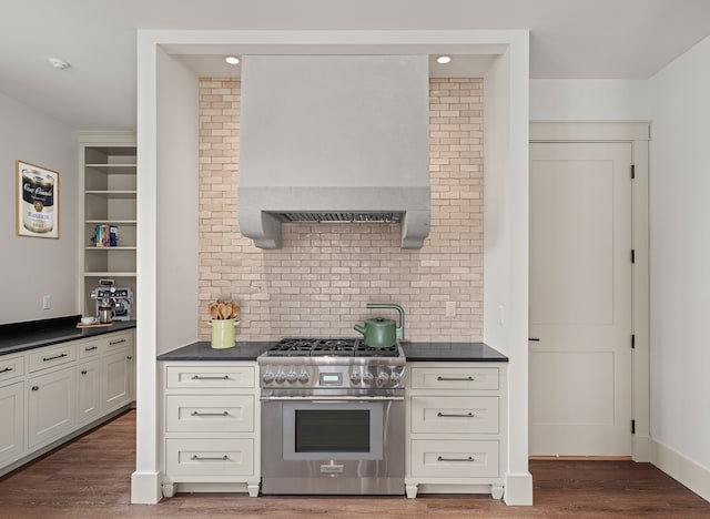 kitchen with high end stove, dark countertops, and wood finished floors