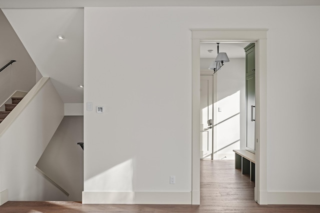 interior space with stairs, wood finished floors, and baseboards