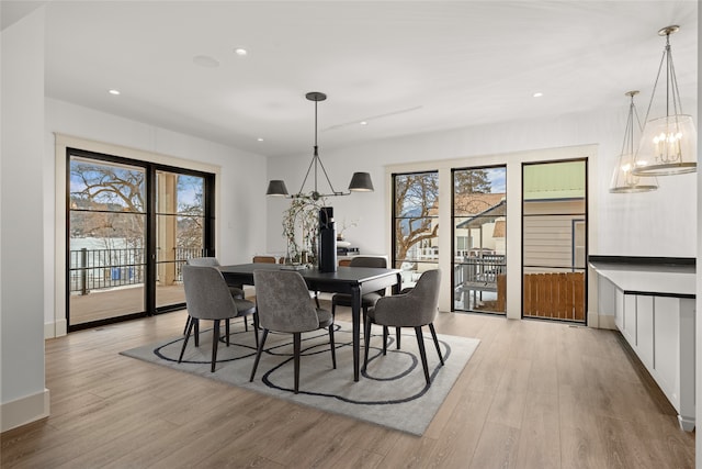 dining room featuring light wood finished floors, recessed lighting, baseboards, and an inviting chandelier