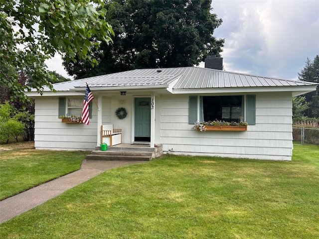 ranch-style home with metal roof, a front lawn, a chimney, and fence