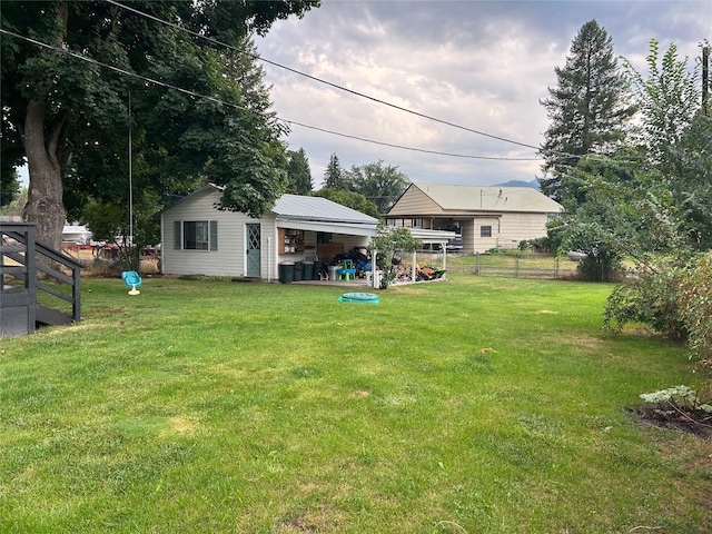 view of yard featuring an outdoor structure and fence