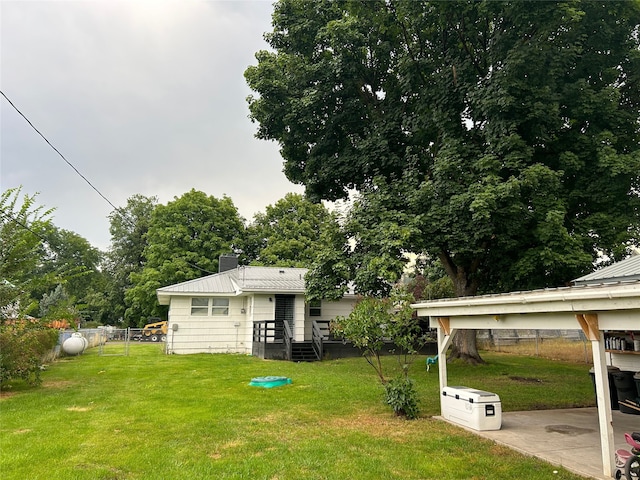 rear view of house with a patio area, a chimney, fence, and a lawn