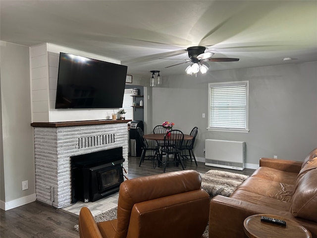 living area featuring ceiling fan, baseboards, wood finished floors, and heating unit