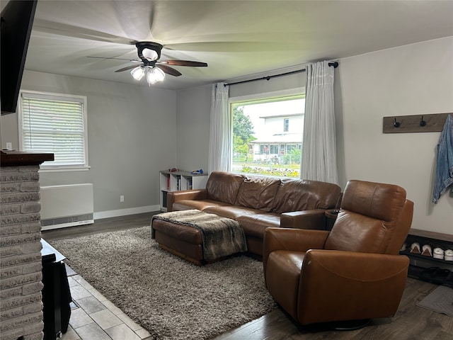 living room with baseboards, a ceiling fan, and wood finished floors