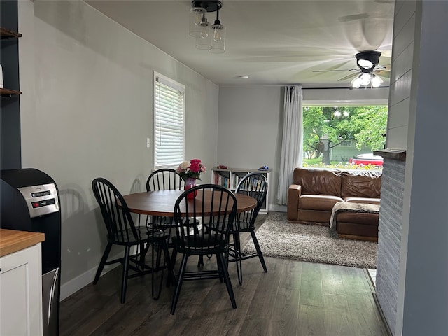 dining area featuring dark wood-type flooring, a healthy amount of sunlight, ceiling fan, and baseboards