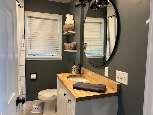 bathroom with toilet, a shower with shower curtain, and vanity