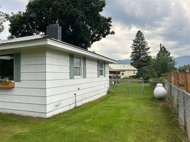 view of property exterior featuring a chimney, central air condition unit, a lawn, metal roof, and fence