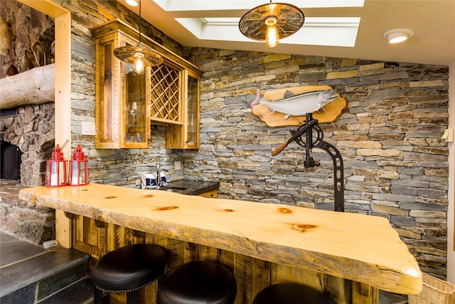 bar with lofted ceiling, indoor wet bar, a sink, and decorative light fixtures