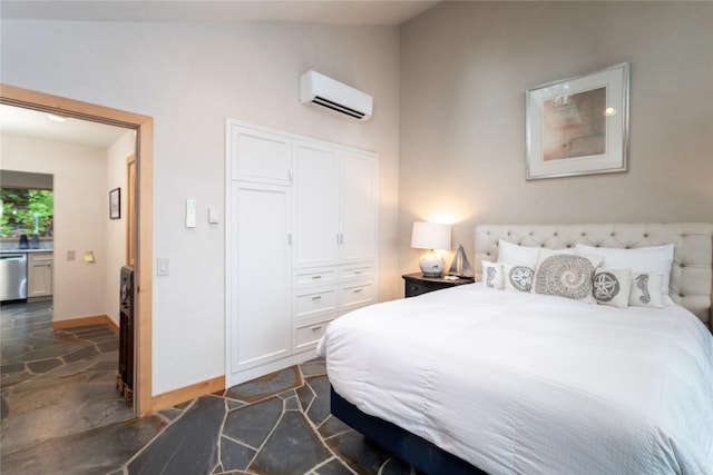 bedroom featuring lofted ceiling, baseboards, a wall mounted AC, a closet, and stone tile flooring