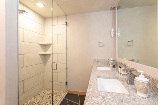 bathroom featuring double vanity, a stall shower, and a sink