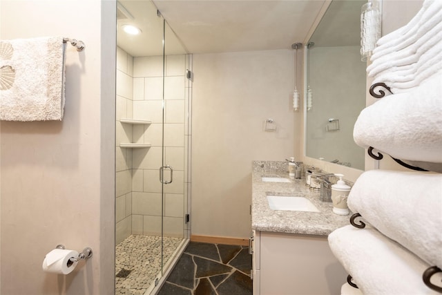 bathroom featuring a stall shower, baseboards, and a sink