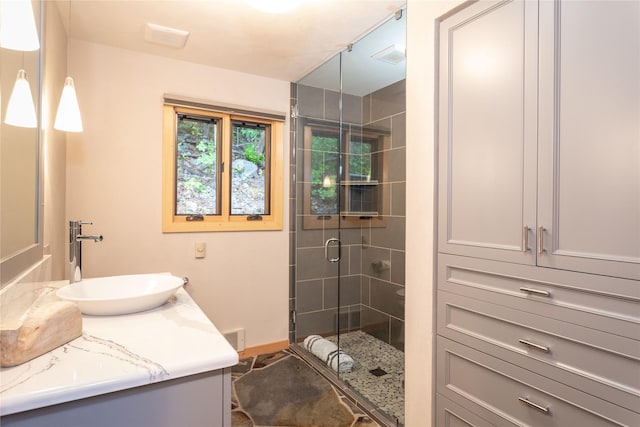 full bath with a stall shower, baseboards, visible vents, and vanity