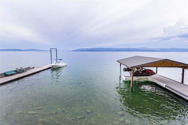 view of dock with boat lift and a water and mountain view