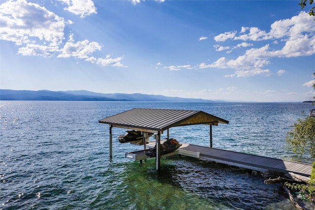 dock area with boat lift and a water and mountain view