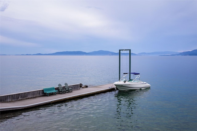 view of dock with a water and mountain view