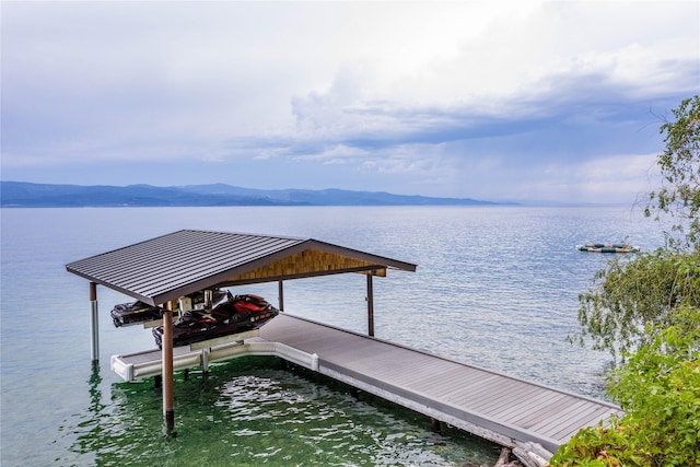 view of dock featuring boat lift and a water and mountain view