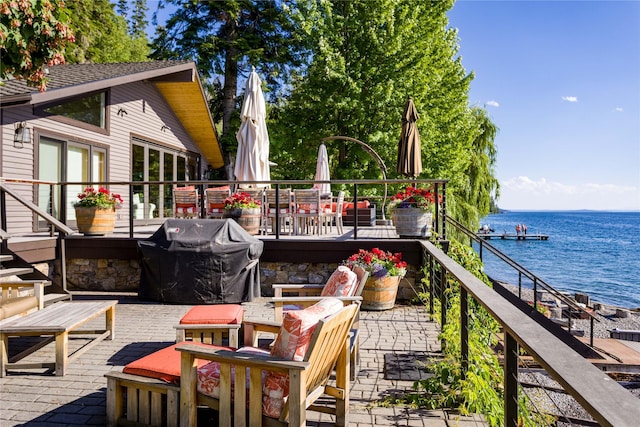 exterior space with grilling area and a deck with water view