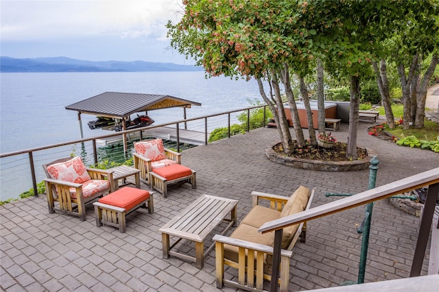 view of patio / terrace with a water and mountain view