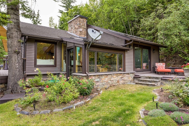 view of front of home featuring stone siding, a chimney, a patio, and a front yard