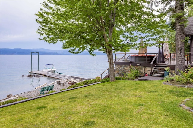 view of yard featuring a water view, a boat dock, and stairs