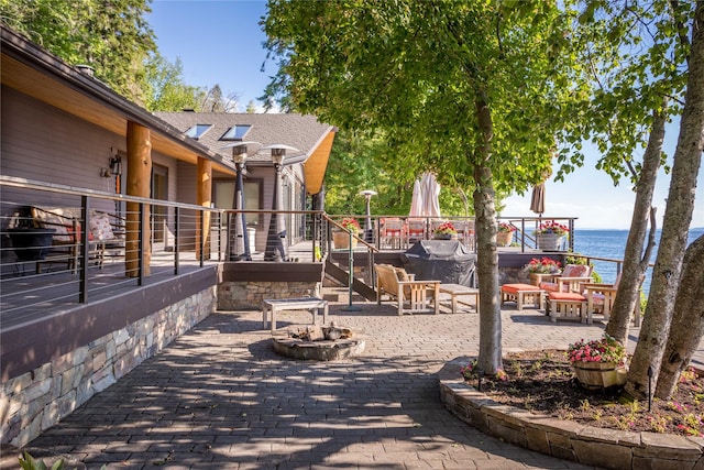 view of patio featuring a fire pit, grilling area, and a water view