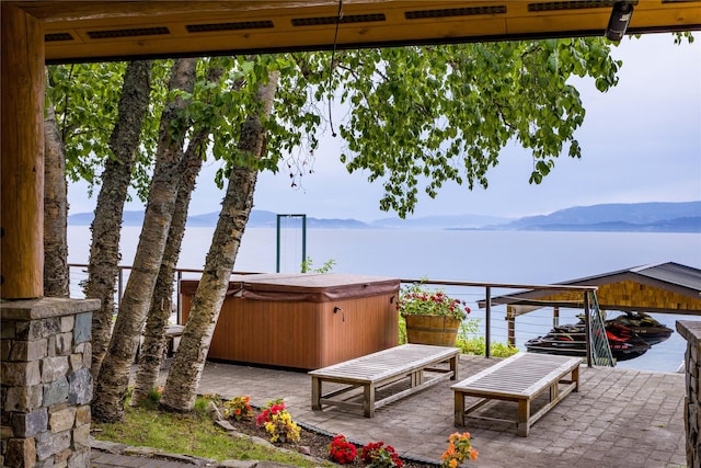 view of patio with a hot tub and a mountain view