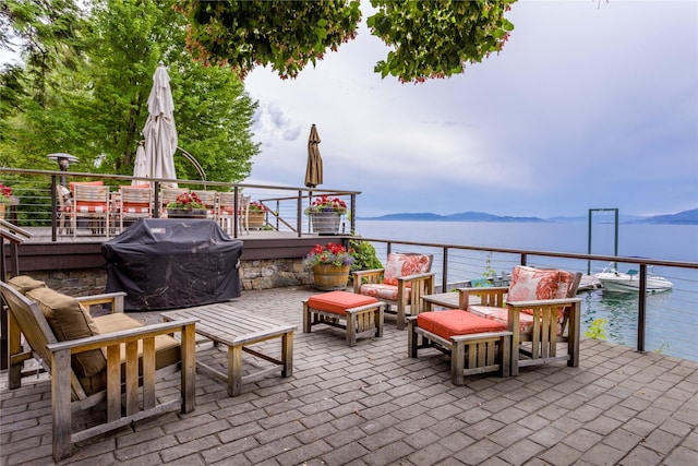 view of patio / terrace with an outdoor hangout area, area for grilling, and a water and mountain view