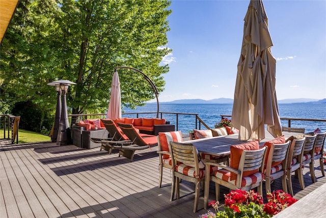 wooden deck with an outdoor living space and a water and mountain view