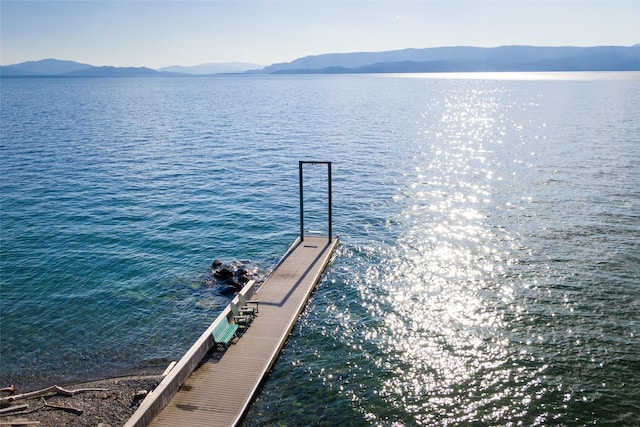 view of dock with a water and mountain view