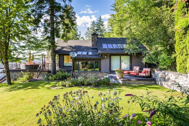 back of property with stairs, a patio, a lawn, and a chimney