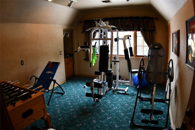 workout area featuring vaulted ceiling, carpet flooring, visible vents, and rail lighting