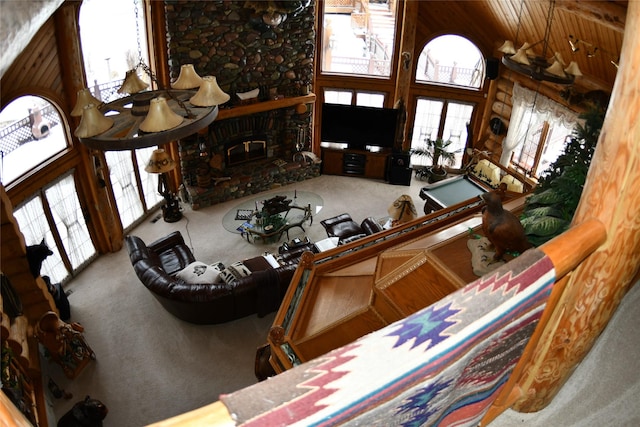 carpeted living room featuring a brick fireplace and a high ceiling