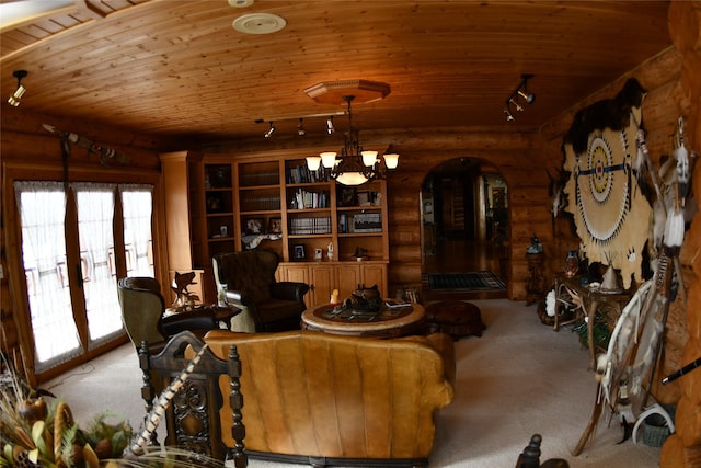 living area with carpet floors, arched walkways, a notable chandelier, rail lighting, and wooden ceiling