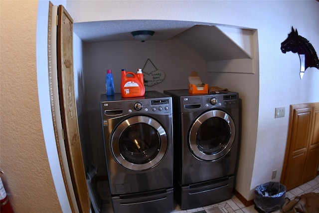 laundry area with laundry area, washer and clothes dryer, baseboards, and tile patterned floors