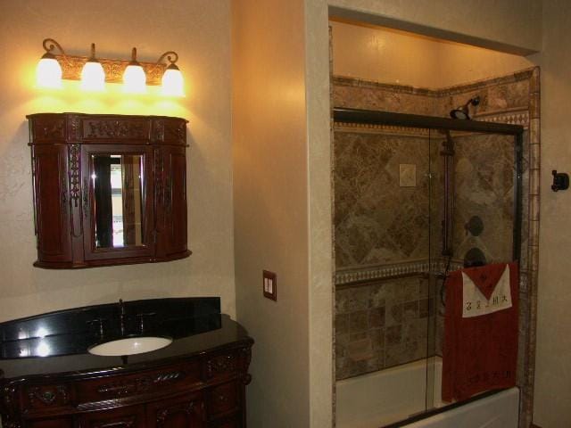 full bathroom with enclosed tub / shower combo and vanity